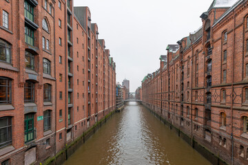 Naklejka premium Germany's second largest city Hamburg streets canals and symbolic buildings snow and colorful cloudy sky and daylight in winter