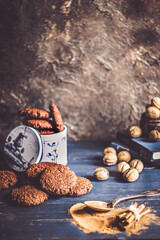 Spiced cookies and cinnamon on wooden background.