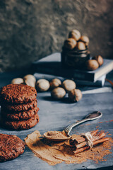 Spiced cookies and cinnamon on wooden background.