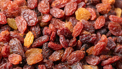 Raisins texture background, closeup, top view. Heap of dried red grapes, selective focus photo; blurred foreground and backdrop - Powered by Adobe