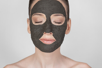 Portrait of a beautiful girl wearing a clay mask