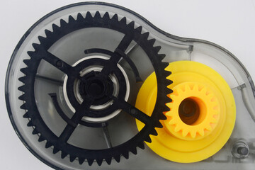 Black and yellow plastic gear, mechanical device from eraser tape - obrazy, fototapety, plakaty