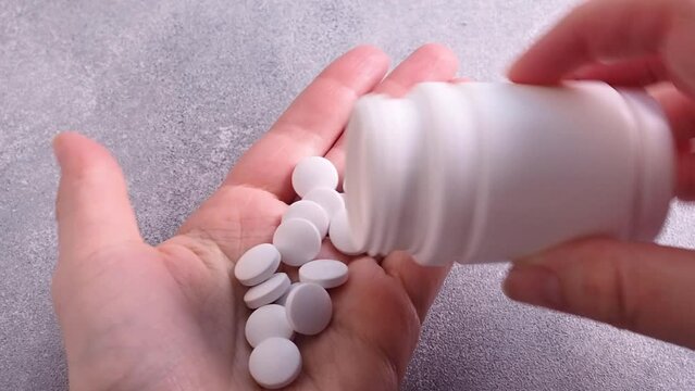 Pour the white pills out of the vials. The concept of health, treatment. Medicines and vitamins. Close-up