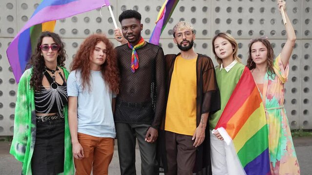 Group Portrait of alternative queer friends having fun holding LGBT rainbow flags 