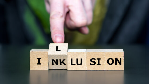 Hand dreht W&uuml;rfel und &auml;ndert das Wort Inklusion in Illusion. Symbol f&uuml;r eine fehlgeschlagene Inklusion.