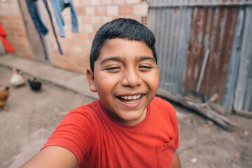 Latino kid smiling looking at the camera while taking a selfie