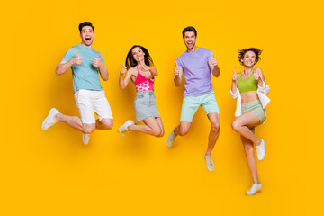 Full length photo of excited people jump make fune symbol demonstrate good choice promo isolated shine color background