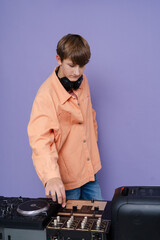 Young and handsome DJ playing music 