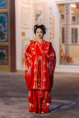 Fototapeta premium Woman dress China New year. portrait of a woman. person in traditional costume. woman in traditional costume. Beautiful young woman in a bright red dress and a crown of Chinese Queen posing.