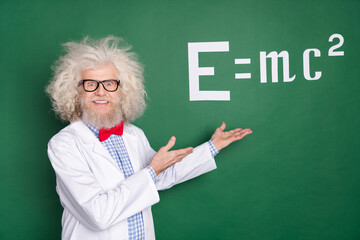 Photo of crazy old professor hold hands present formula wear glasses isolated on green color...