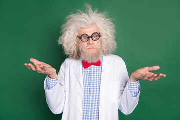 Photo of funky funny crazy scientist in glasses messy hair shrug shoulders doubtful isolated on green color background - obrazy, fototapety, plakaty