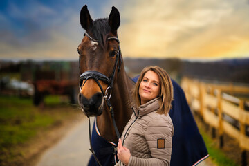 Woman with horse in portraits on a path with dramatic sky in the background.