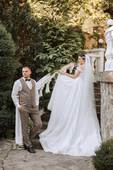 The bride is dressed in an elegant lush white wedding dress with a long veil and is ready for her...