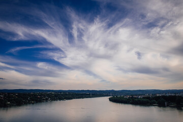 Beautiful panoramic landscape of the Danube River and the city in Serbia on amazing cloudy sky background.