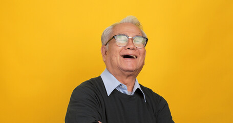 Close up, portrait of older man smiling and looking at the camera. Isolated on yellow background in the studio.