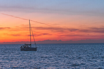 Sailing boat on the sea in summer with sunset sky
