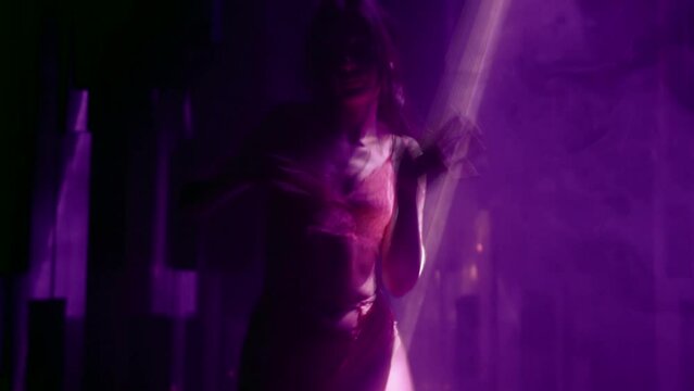 alluring brunette woman in lingerie dancing in dark nightclub with laser rays, silhouette of lady