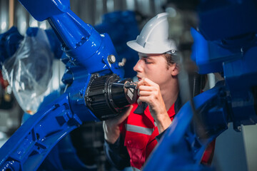 Maintenance Team Repairing Industrial Robotic Arm.