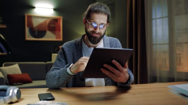 Young man relax alone at home sitting at home, holding digital tablet enjoy e-date services, surfing web, studying online, shopping on internet use social media apps. Modern device usage concept