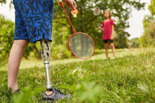 Boy with amputated leg playing badminton at park
