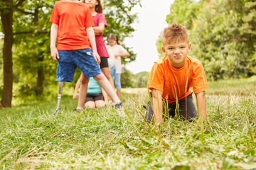 Boy kneeling on grass at park