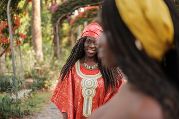 Woman in the foreground out of focus and behind in focus a woman with a typical African costume