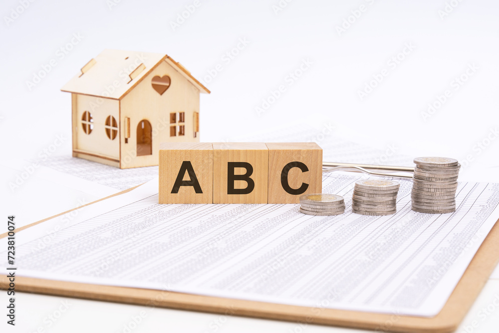 Poster cubes form the text abc. on a light background there is a row of cubes and a toy house in the backgr