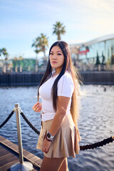 Beautiful asian woman in white t-shirt and shorts posing on the pier