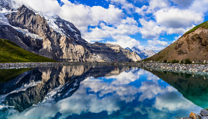 Switzerland nature .  panoramic view of Fallboden lake with turquoise water and reflections of snowy peaks. Kleine Scheidegg mountain pass famous for hiking in Bernese Alps.Swiss travel - 723812678