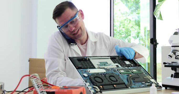 Repairing and testing computer equipment and male engineer talking on phone with client