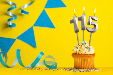 Birthday candle number 115 with cupcake - Yellow background with blue pennants