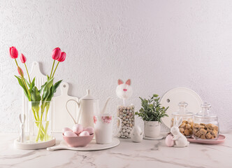 Stylish kitchen background for Easter holiday with traditional symbols and white tableware. foreground. Easter holiday concept.