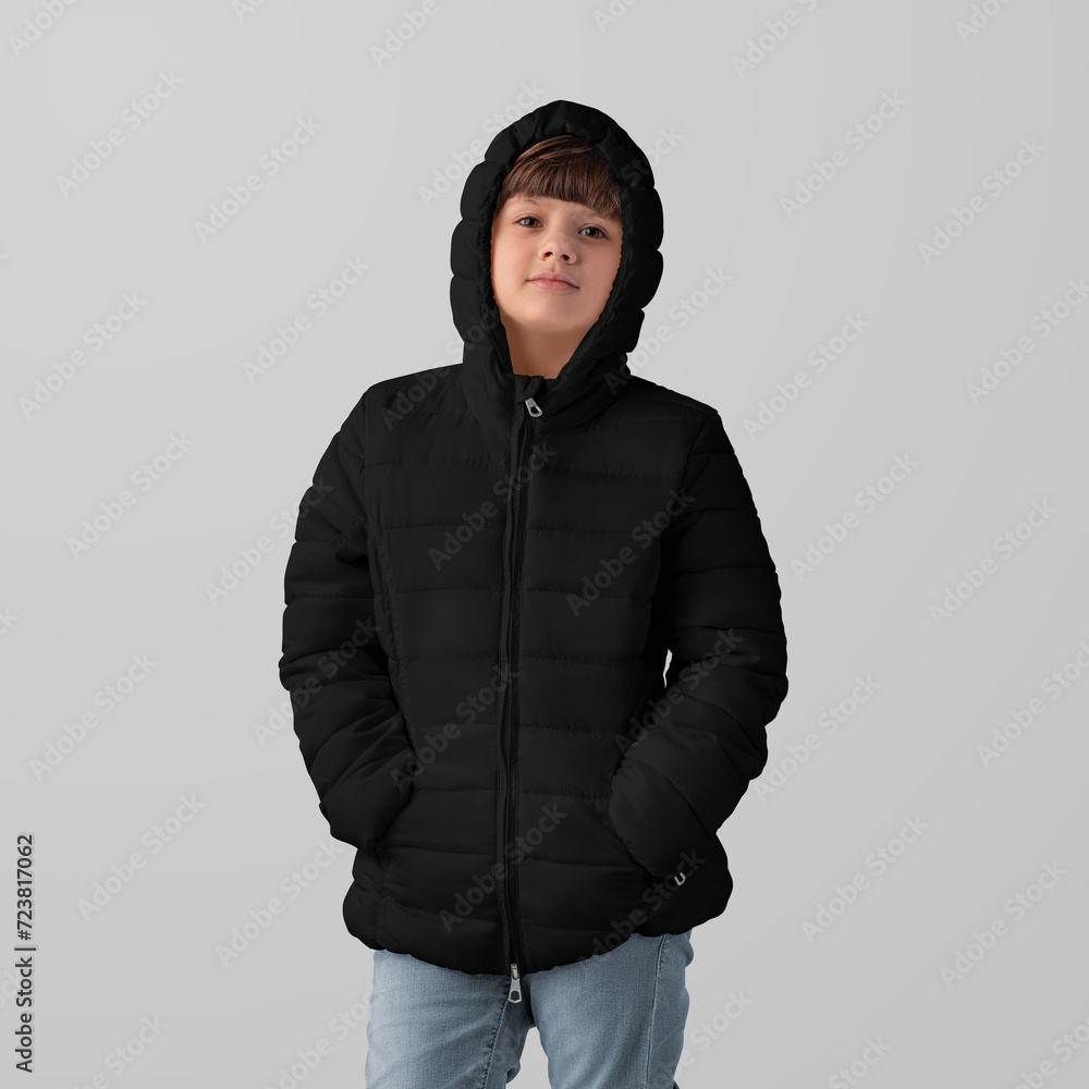 Wall mural Mockup of black winter kids puffer jacket on hooded girl, front view, isolated on background in studio.