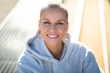 Close up smiling woman with shaved hair - obrazy, fototapety, plakaty