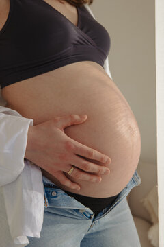 close up of a pregnant woman holding her baby belly