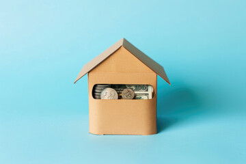 A paper house with money inside. Savings for the purchase of housing
