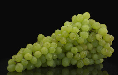 Big bunch of green grapes with water drops on black background