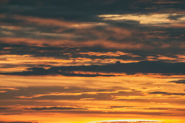 Dramatic sunset sky. Warm cloudscape background. Twilight sunlight. Dusk light scene.
