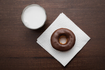 Overhead view of a chocolate covered donut and glass of milk