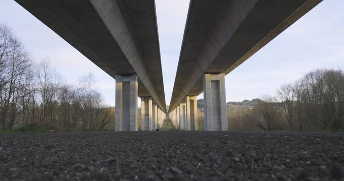 Highway bridge underpass structure with concrete columns on a blue sky background with sunlight
