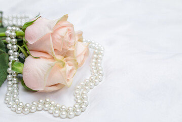 The branch of pink rose on white fabric background
