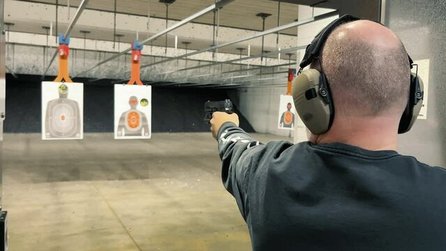 Shooting Range Practice, Person practicing firearm shooting at indoor range targets