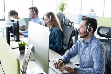 Colleagues working in a call center. - obrazy, fototapety, plakaty
