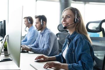 Colleagues working in a call center. - obrazy, fototapety, plakaty