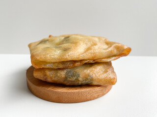 Martabak, made from flour dough, egg and leek slices. Snack from Indonesia. Isolated on white background
