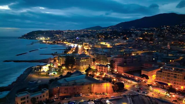 Aerial view of Sanremo at night, Italy. Port and city buildings