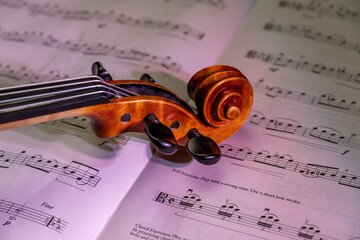 Detailansicht einer Geige mit Schnecke und Wirbelkasten vor Noten, Studioaufnahme, Deutschland