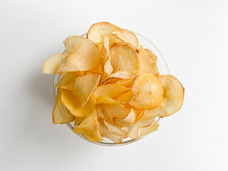 Cassava chips, in a transparent bowl, isolated in white background