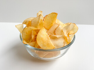 Cassava chips, in a transparent bowl, isolated in white background