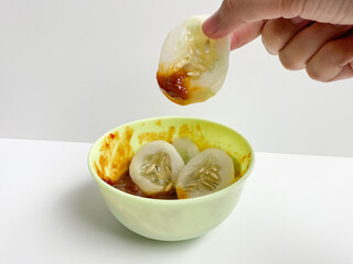 Rujak, traditional salad from Indonesia, consist of cucumber slices and sambal rujak or spicy salad dressing paste. Isolated on white background